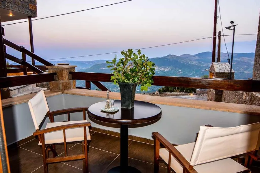 Μπαλκόνι με τραπεζάκι και καρέκλες, με θέα στα βουνά